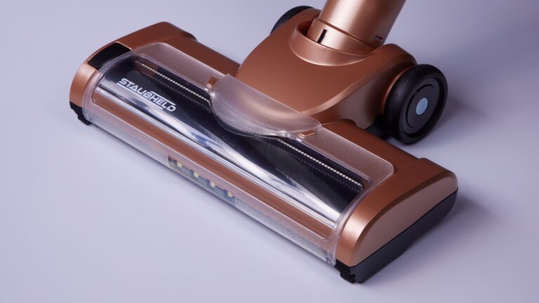 Bronze-coloured cordless vacuum floor head with a visible brush roller