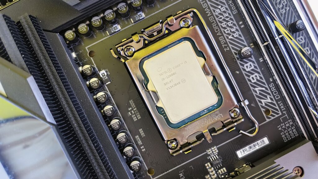 Intel Core i5-12600K desktop processor secured in a motherboard socket beside memory slots.